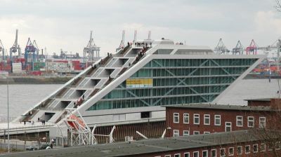 Dockland
Ein glsernes, 7-geschossiges Parallelogramm ragt wie ein Schiffsbug 40 Meter frei ��ber die Elbe. Geplant vom Architektenteam Bothe Richter Teherani, steht es auf einem eigens daf��r aufgesch��tteten Grundst��ck zwischen dem Fischereihafen und der Elbe und stellt ein neues Tor zur Stadt�� dar. Die ��ber Freitreppen zu erreichende Aussichtsflche bietet einen atemberaubenden Blick ��ber die Elbe.
Schlüsselwörter: Dockland Hamburg